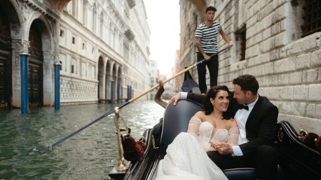 Pareja de recién casados viajando en góndola por un canal de Italia
