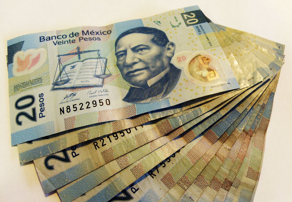 Billetes de pesos mexicanos extendidos sobre una superficie, que ilustran el ahorro en Cetes