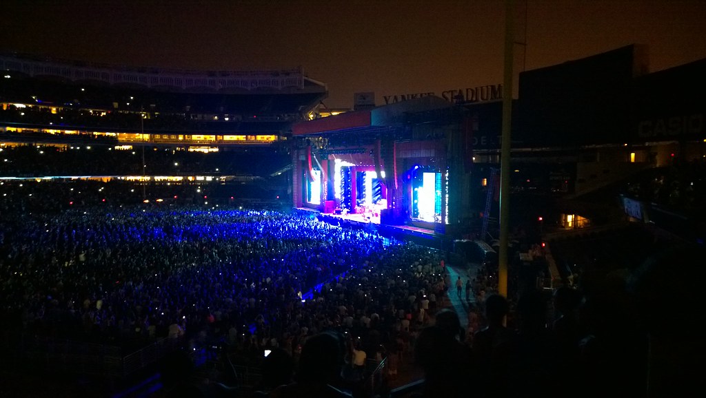 Multitud en un concierto de estadio con luces y manos en alto