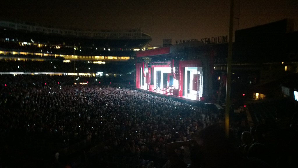 Escenario de concierto con luces y público durante un espectáculo masivo