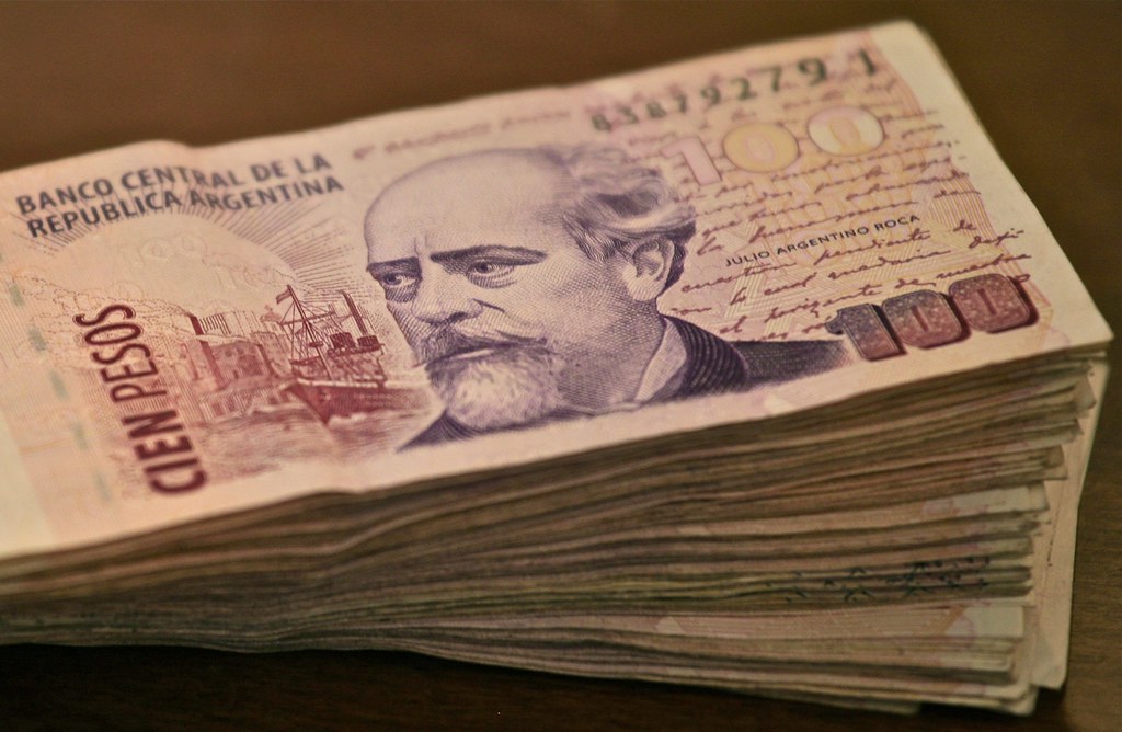 Billetes de peso mexicano y dolares sobre una mesa de operaciones que ilustran el precio del dolar hoy