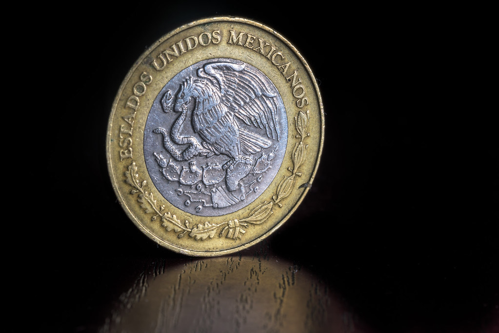 Monedas mexicanas de veinte pesos apiladas sobre una superficie