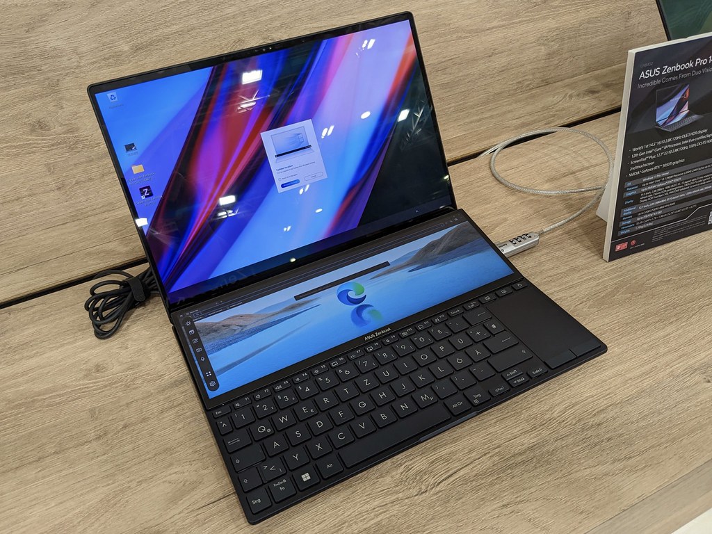 Laptop ultradelgada con pantalla OLED encendida sobre un escritorio