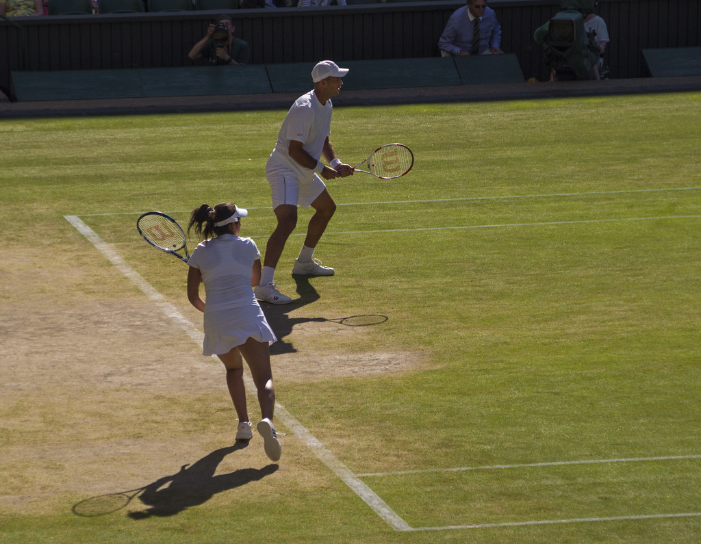 Tenistas disputando un punto sobre la hierba de una pista de Wimbledon