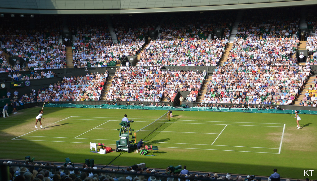 Pista central de Wimbledon con las gradas llenas durante un partido sobre césped