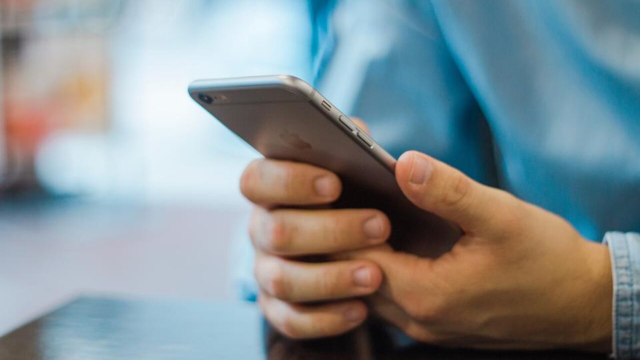 Persona sosteniendo un iPhone en la mano
