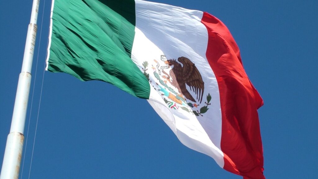 Bandera de Mexico ondeando bajo el cielo azul