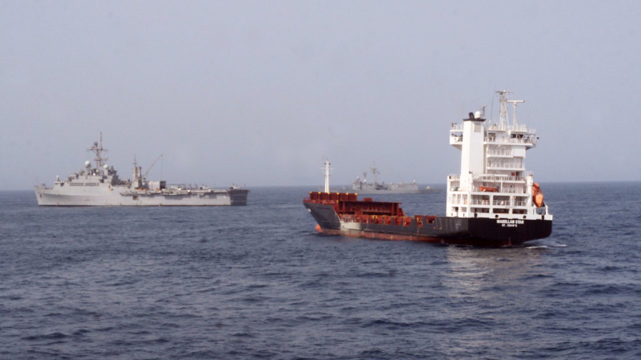 Buques de carga y navíos militares navegando en el mar