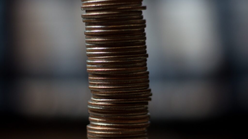 Monedas doradas sobre una superficie de madera que ilustran el rendimiento de la inversión