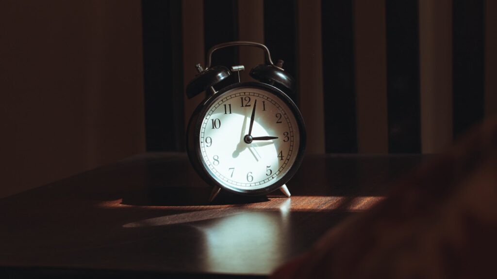 Reloj despertador sobre una mesa de madera durante la noche