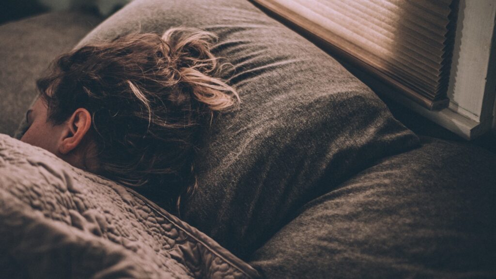 Mujer durmiendo plácidamente en la cama bajo las cobijas