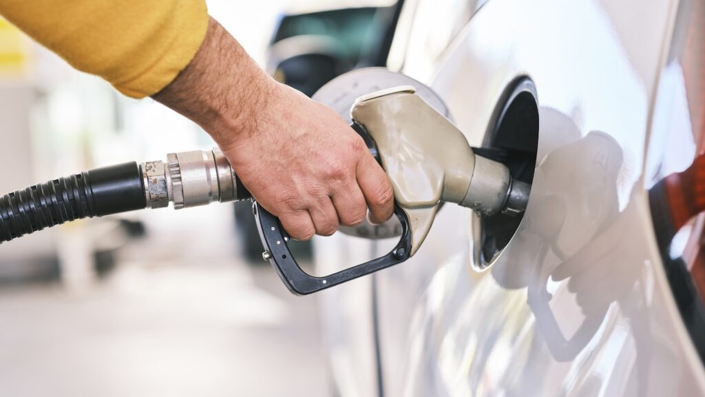 Persona cargando gasolina en una estación de servicio