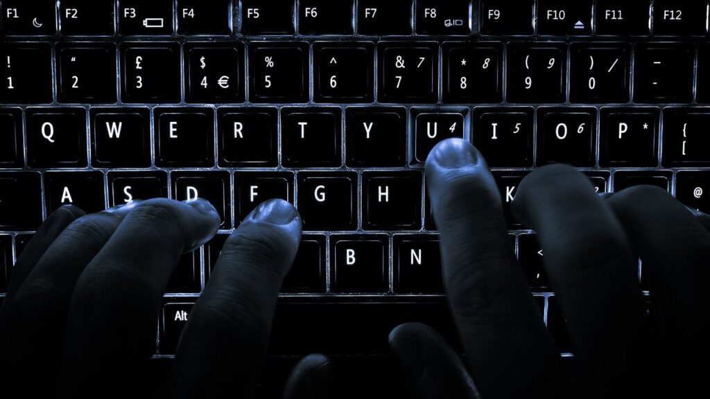 Persona escribiendo en el teclado de una computadora portátil