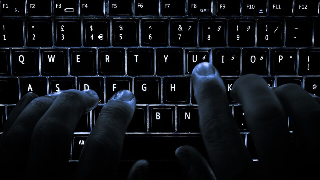 Persona escribiendo en el teclado de una computadora portátil